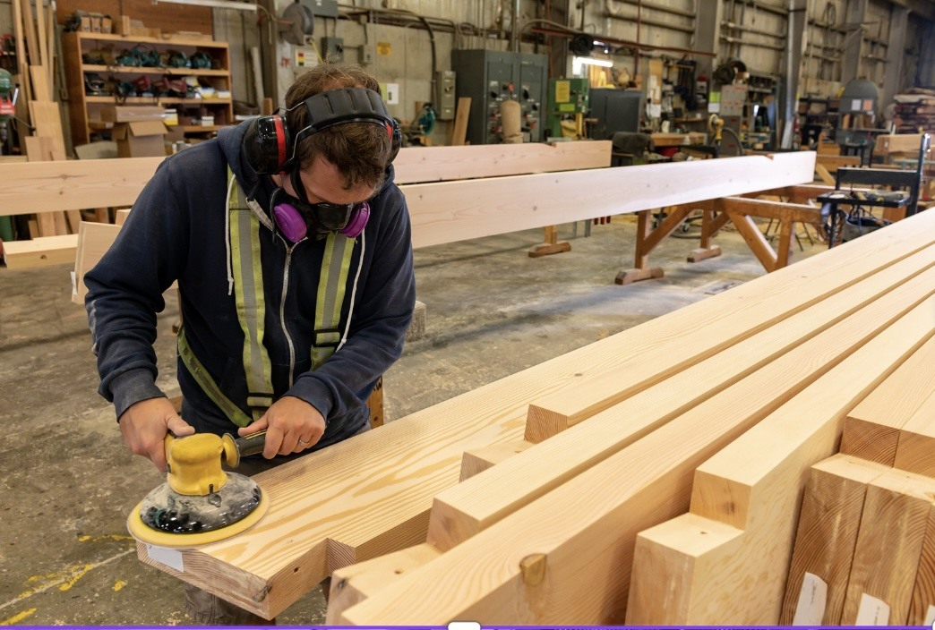 Wearing safety equipment cutting timber